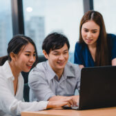 Collaborative process of multicultural businesspeople using laptop presentation and communication meeting brainstorming ideas about project colleagues working plan success strategy in modern office.